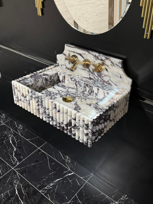 Full Ribbed Calacatta Viola Marble Sink, featuring fluted detailing on all sides for a bold architectural look. Handcrafted from premium Viola marble, this floating rectangular basin is paired with a custom Calacatta marble backsplash, creating a harmonious, luxury aesthetic