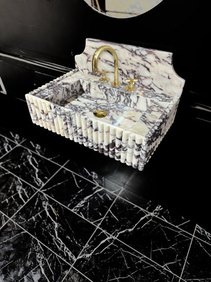 Full Ribbed Calacatta Viola Marble Sink, featuring fluted detailing on all sides for a bold architectural look. Handcrafted from premium Viola marble, this floating rectangular basin is paired with a custom Calacatta marble backsplash, creating a harmonious, luxury aesthetic